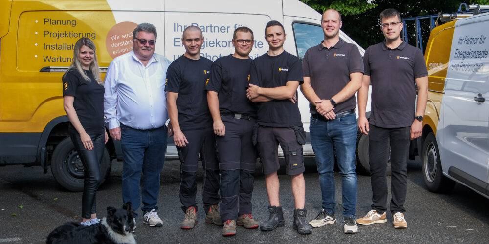 Das Team von enivon in einer Reihe mit Firmenhund